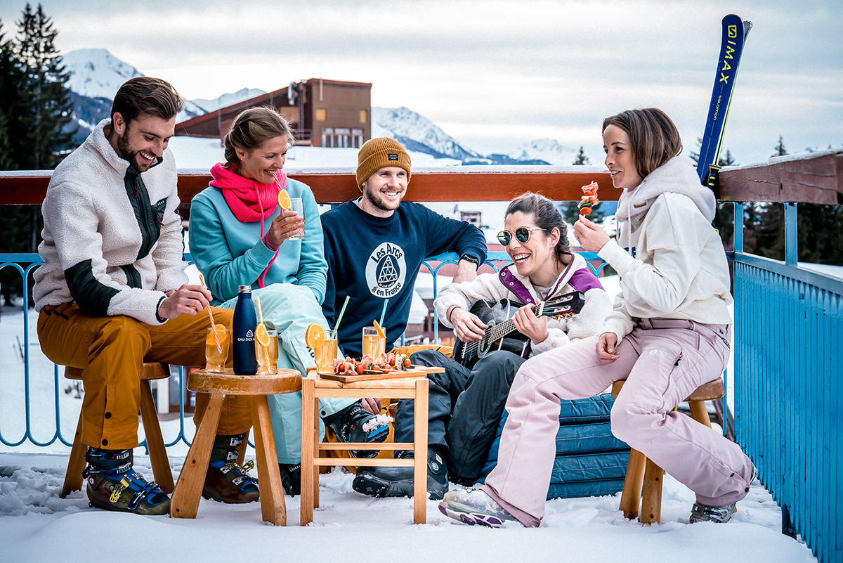 Groupe de jeunes en apres-ski sur une terrasse des arcs 1800. Photo par Merci Creative